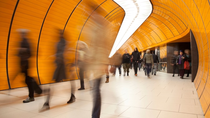 Blurred motion photograph of passengers walking through tunnel in underground transport  network