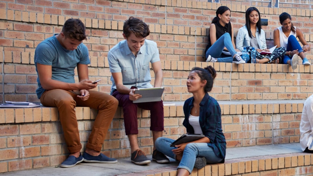 Students sat on steps on learning campus 