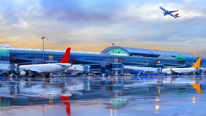 Parked planes on runway by gates