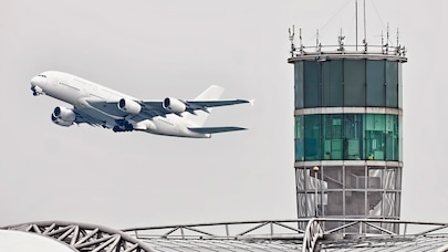 Passenger jet flying past air control tower