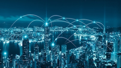 Night city skyline with glowing network connections linking buildings across an urban waterfront.