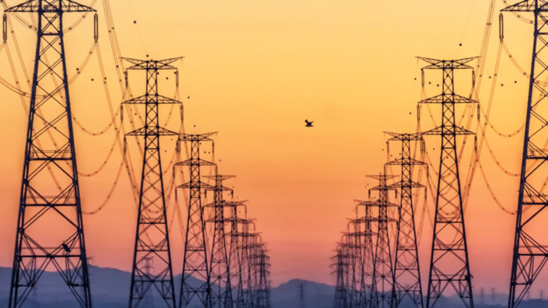 Power transmission towers at sunset supporting LTE/5G private utility networks.