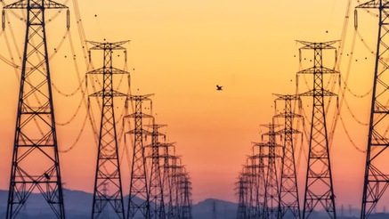 Power transmission towers at sunset supporting LTE/5G private utility networks.