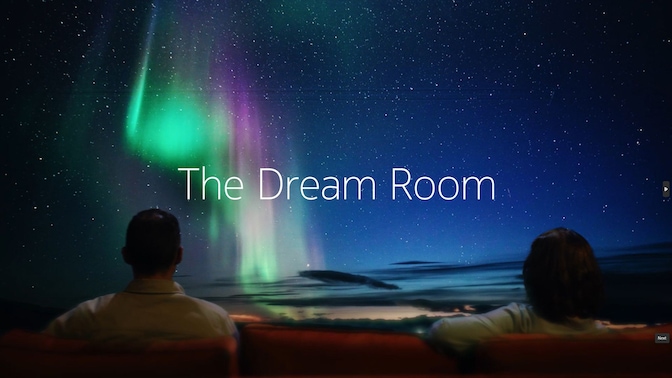 Two people on movie seats looking at the Norther Lights on a screen