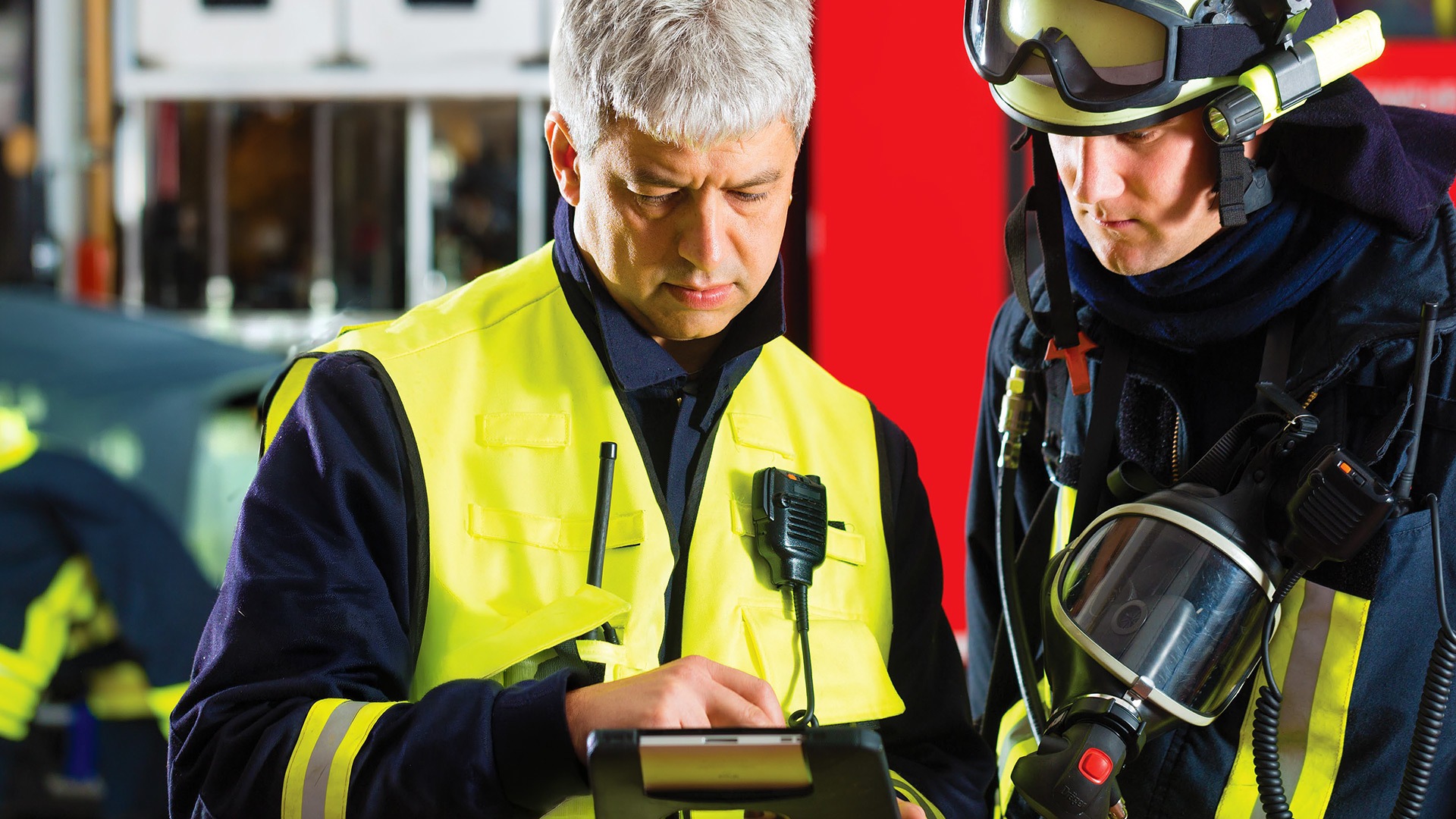 Two fireman looking at tablet