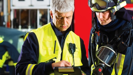 Two fireman looking at tablet