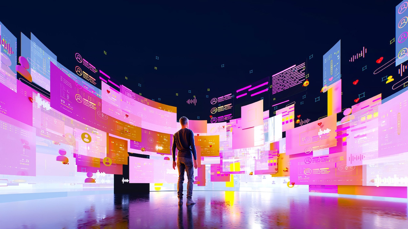 Man standing in front of bank of curved screen full of data visualisations