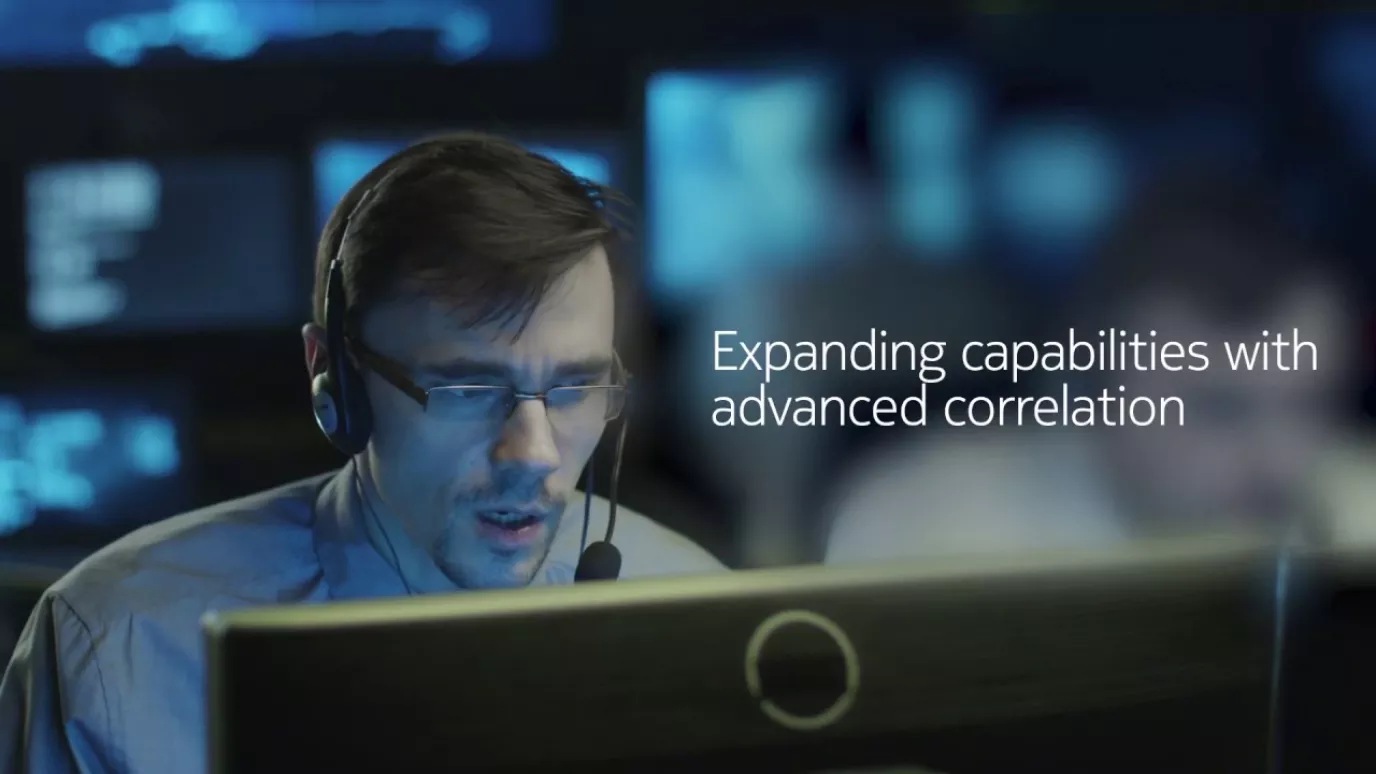 Man wearing headset in situation room looking at monitor screen