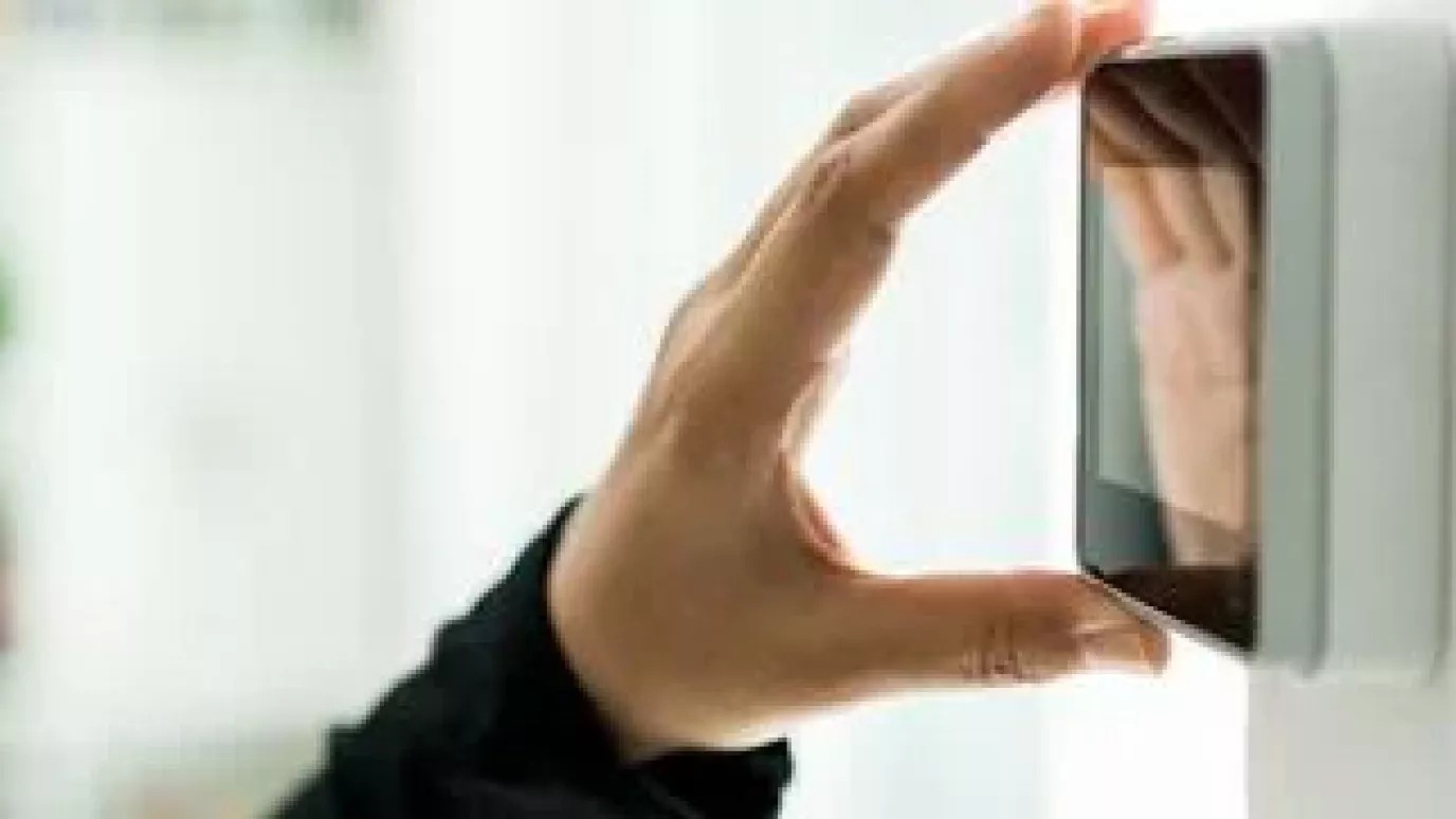 Hand reflected in wall-mounted touchscreen controller