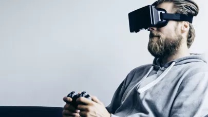 A person playing on a console wearing a VR headset.