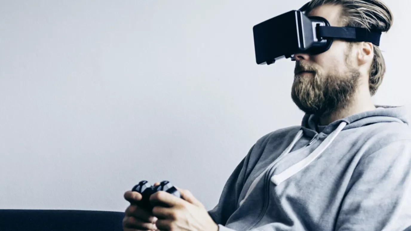 A person playing on a console wearing a VR headset.