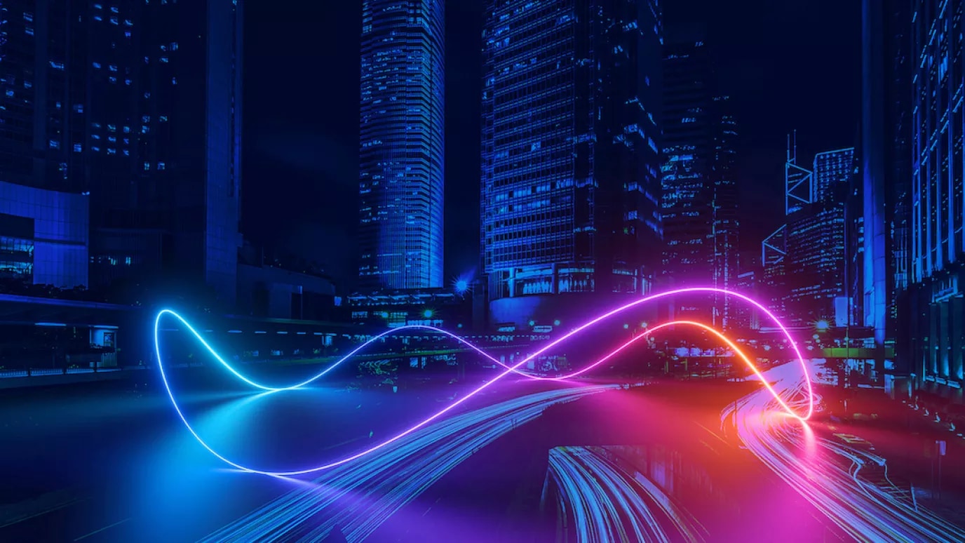 An image of high-rise buildings with colourful neon light swirls in the foreground.