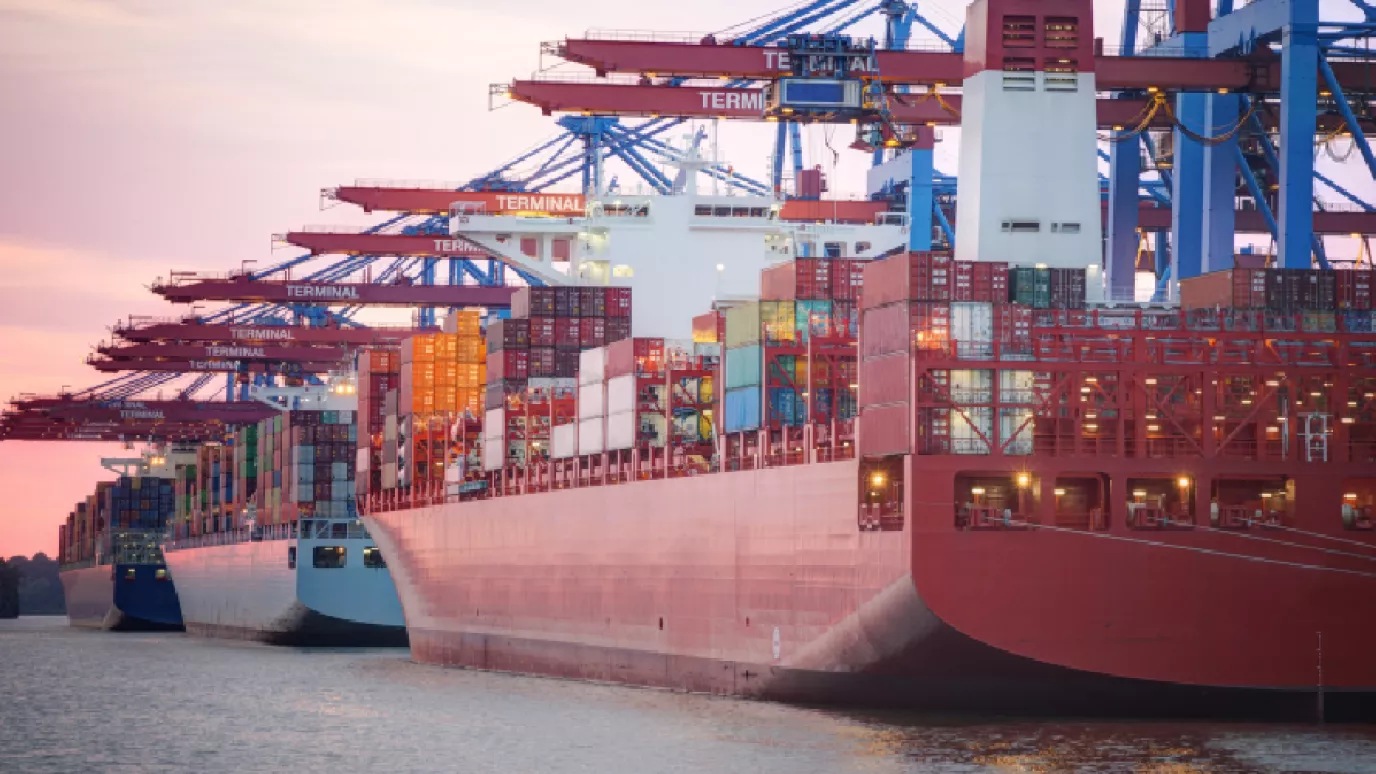 Three cargo ships filled with containers.