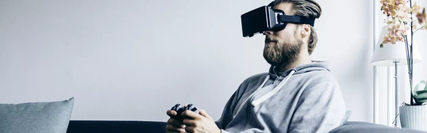 A person playing on a console wearing a VR headset.