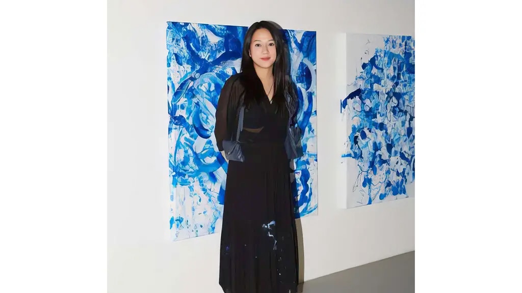 Sougwen Chung standing in front of some of her artwork