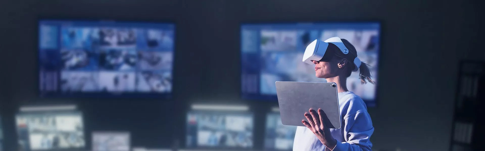 A woman wearing a virtual reality headset with screens in the background.
