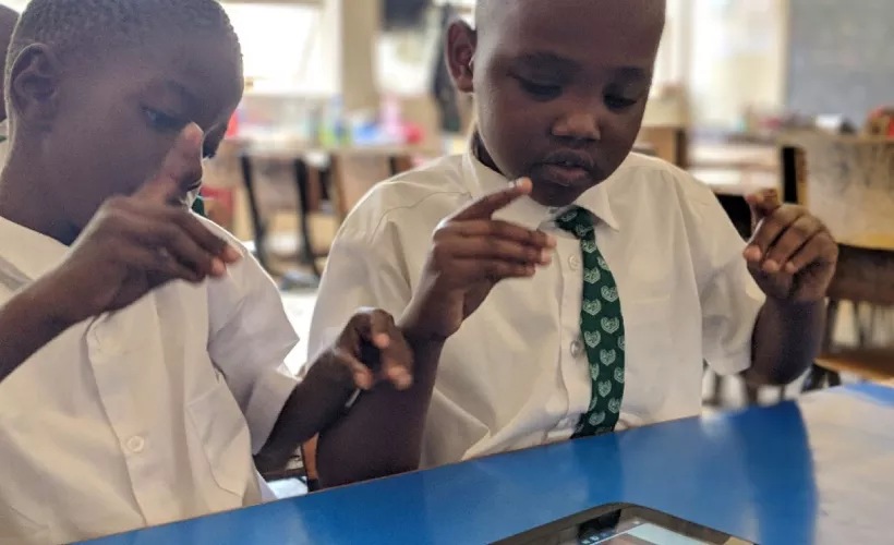 Derrick and Collins from Aga Khan Primary School signing along with the help of the interpreter in the digital accessible textbook.