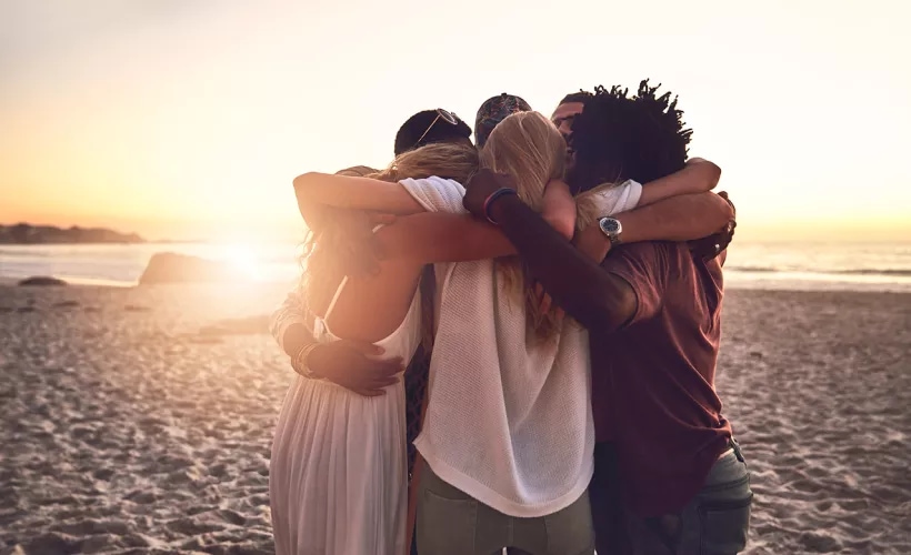People hugging each other on the beach