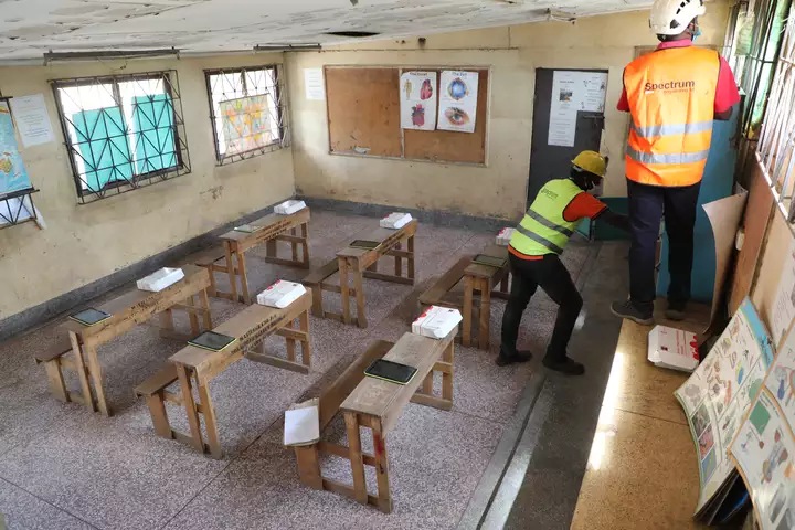 Technicians finish up installation of internet router at Valley Bridge primary school computer library in Mathare