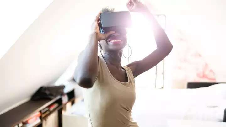 Woman using Virtual Reality headset in living room