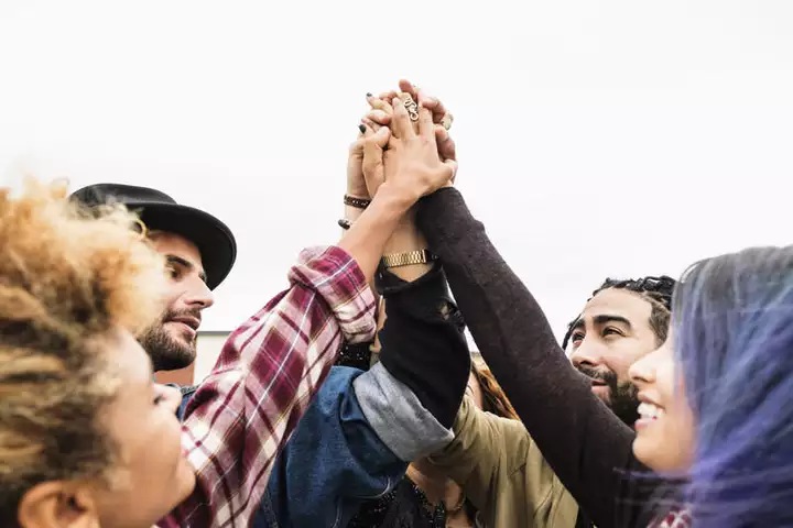 people cheering together and holding hands