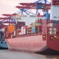 Three cargo ships filled with containers.