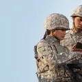 Two soldiers looking at a tablet device