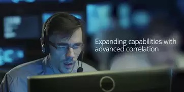 Man wearing headset in situation room looking at monitor screen