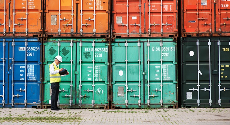 Shipyard worker analysing cargo crates